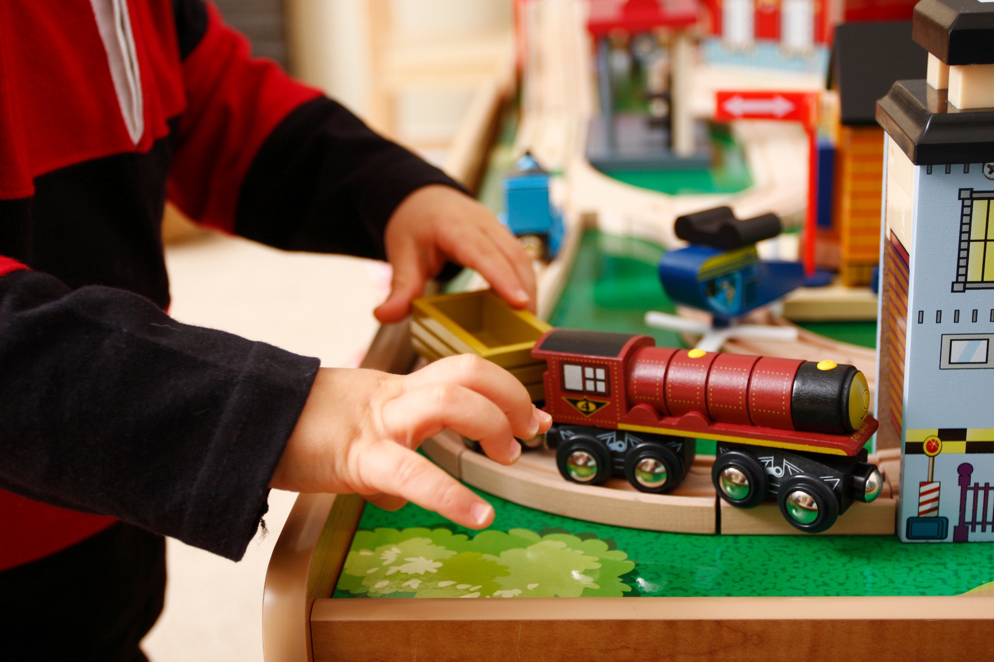 Young toddler playing with a wooden train set