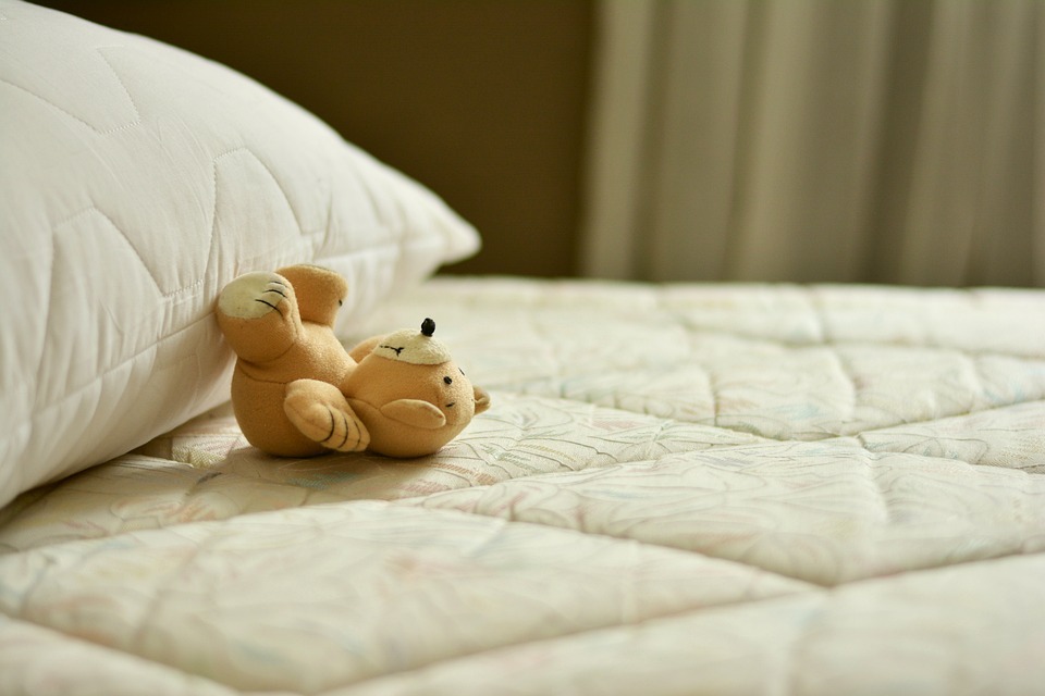 A toy bear on a mattress