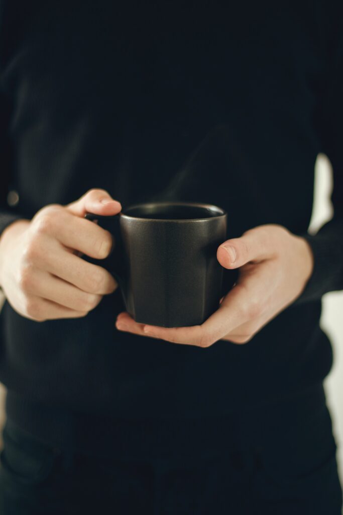 an image of a person holding a cup of coffee