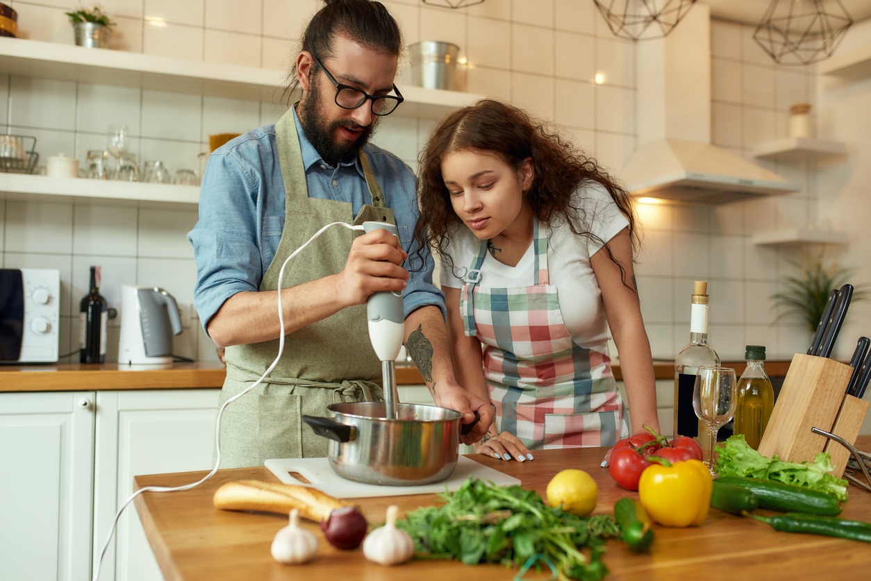 man and woman using an immersion blender