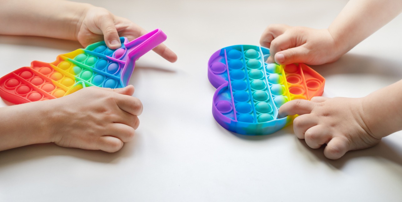 two children playing with colorful pop-it toy