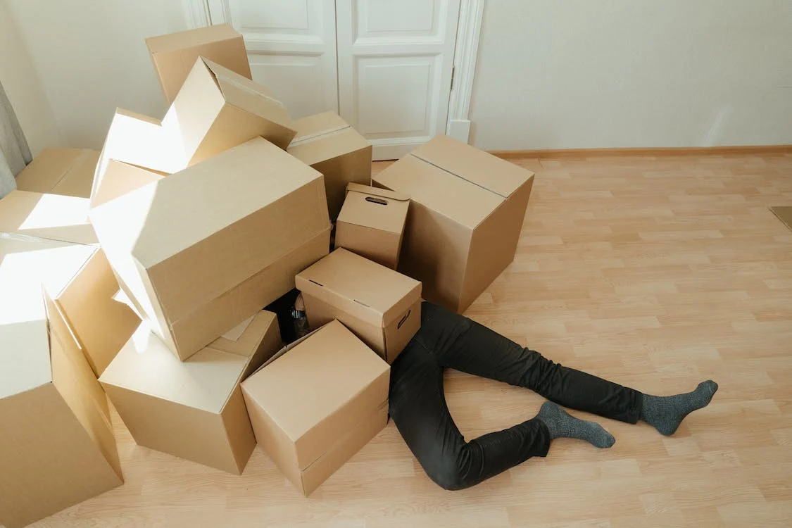 A person covered by cardboard boxes