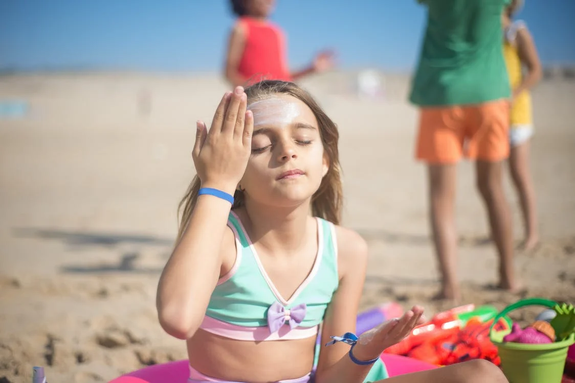 Girl applying sunblock on forehead