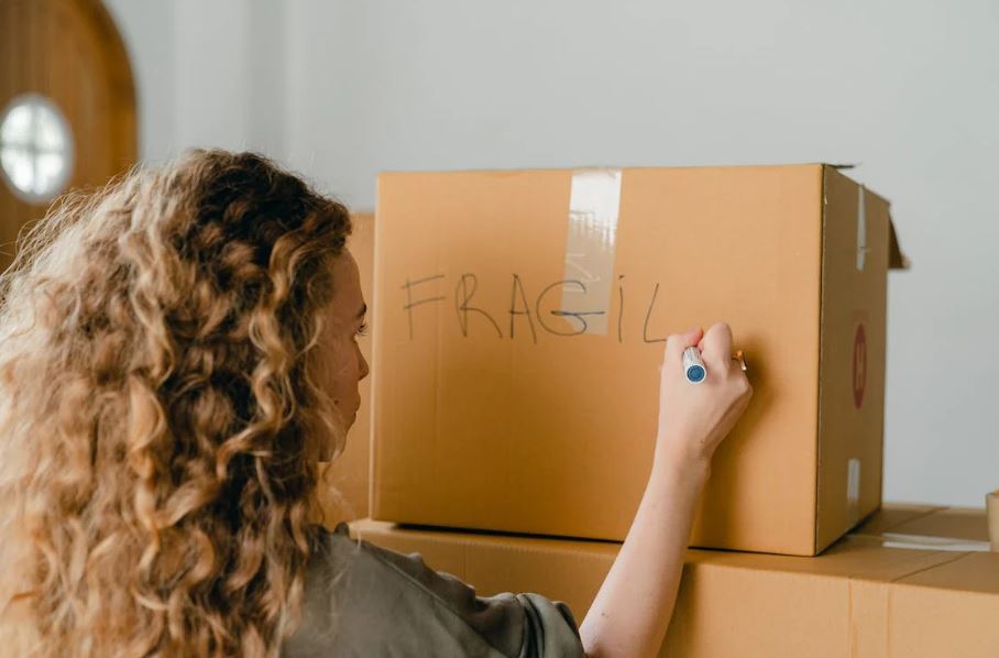 A woman labeling a box
