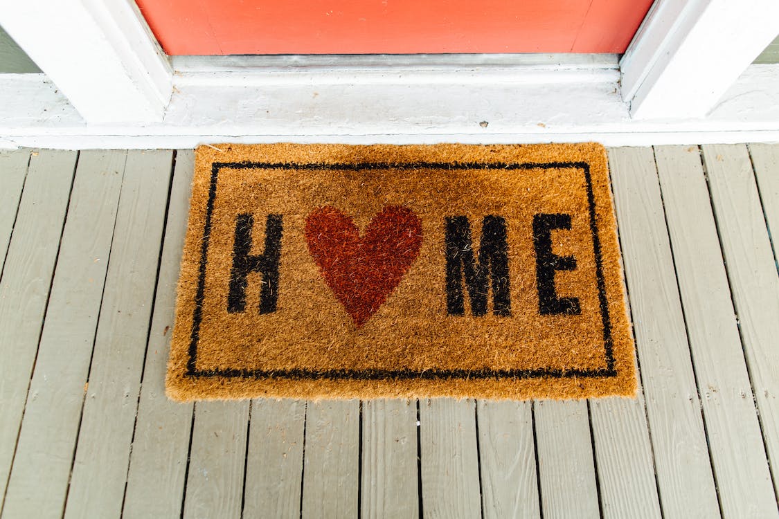 a red doormat with the word welcome
