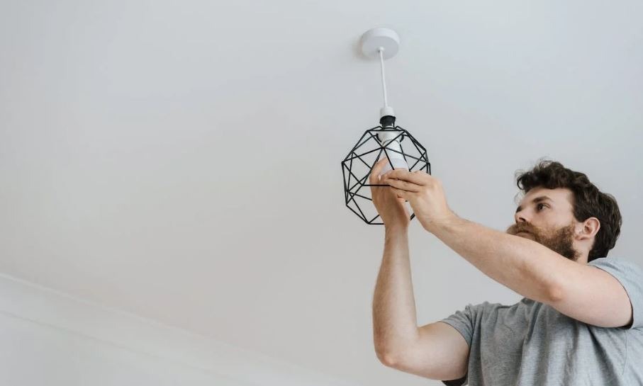 man screwing light bulb