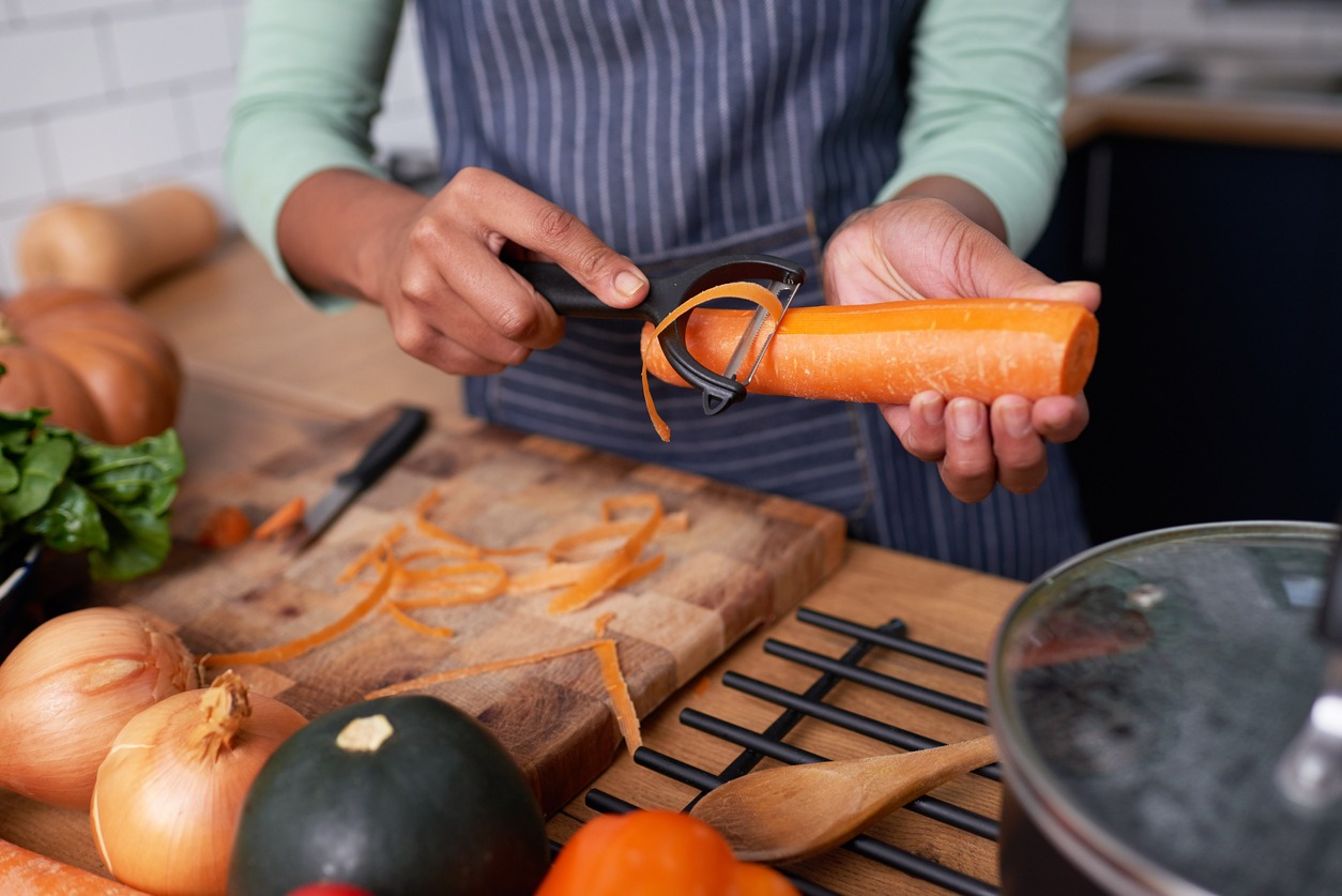 woman peeling a carrot using a Y-peeler