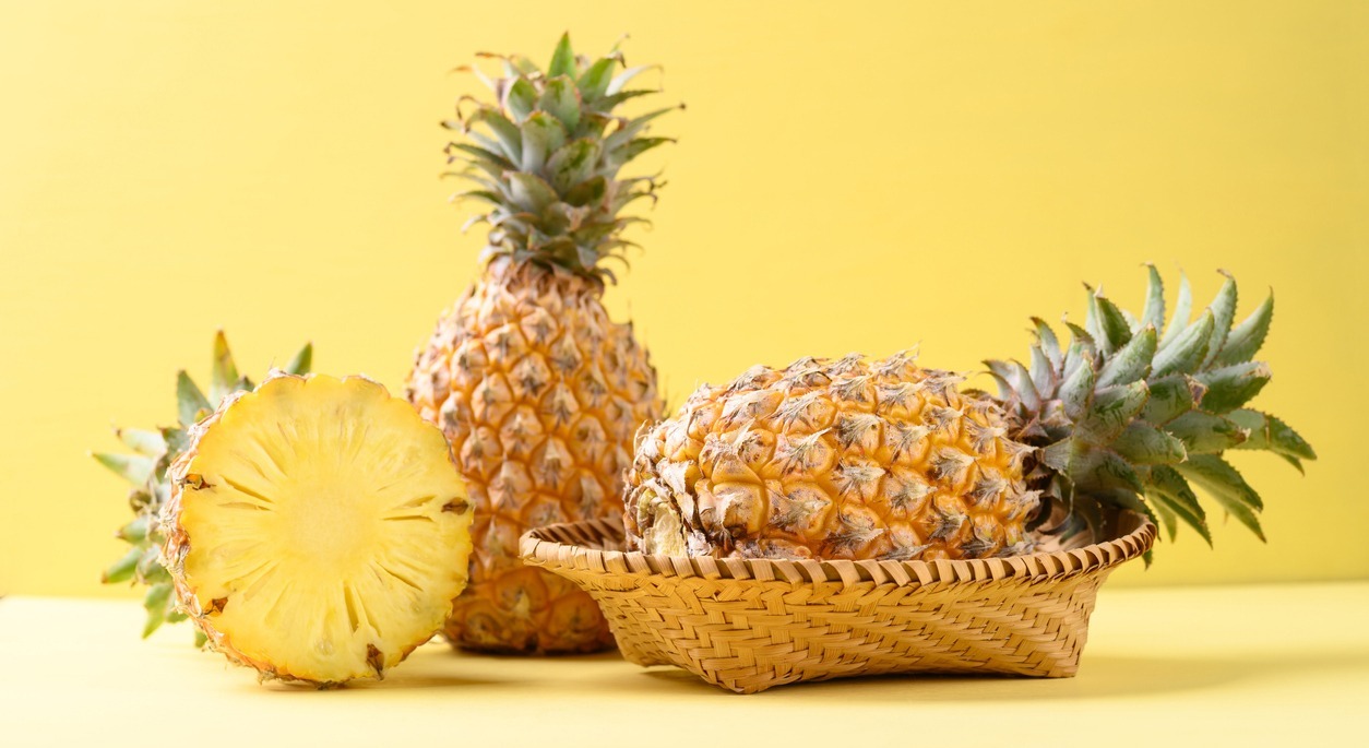 Fresh-pineapple-fruit-in-basket-on-yellow-background