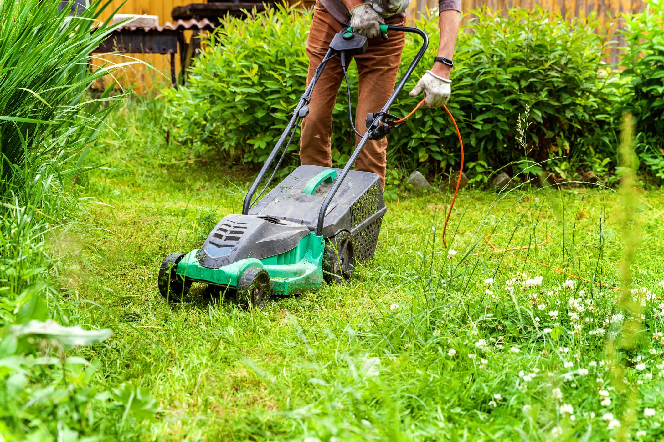 Man-cutting-grass-with-electric-lawn-mower