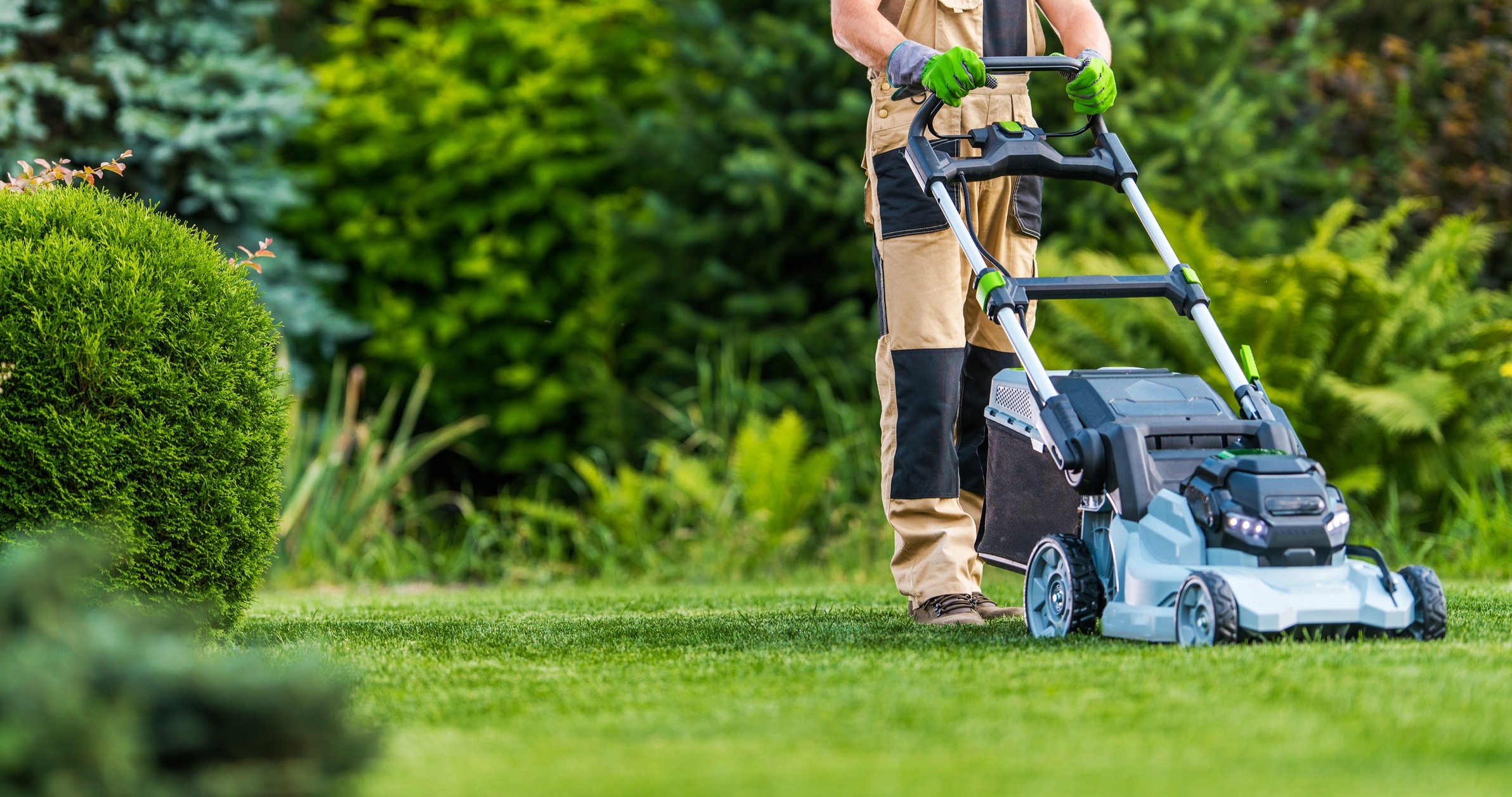 Professional-Caucasian-Gardener-in-His-40s-Trimming-Grass-Lawn-Using-Modern-Electric-Cordless-Mower.-Landscaping-Industry-Theme