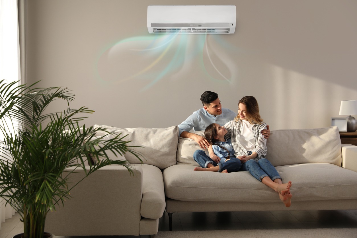 a family enjoying cool air conditioning on a couch in a new room