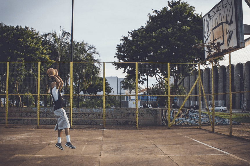A-person-making-a-jump-shot-to-score-a-basket-on-a-local-basketball-court